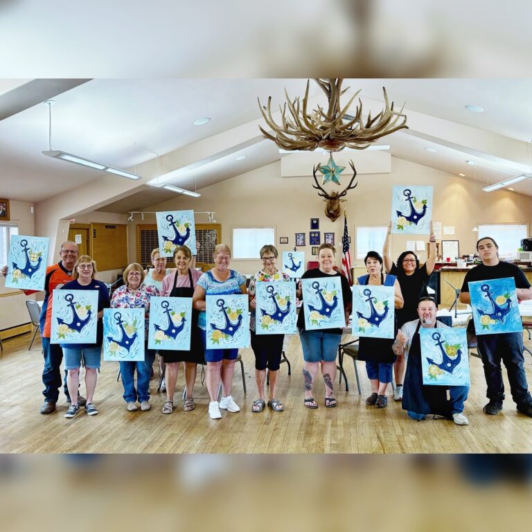 People smiling and showing their painting at an event