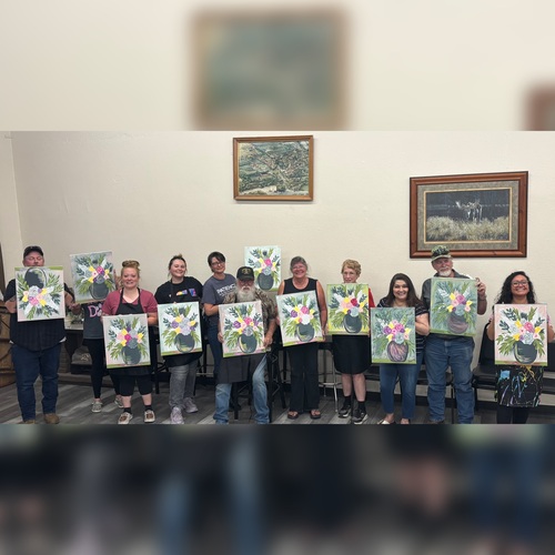 People showing their painting at a Paint and sip event